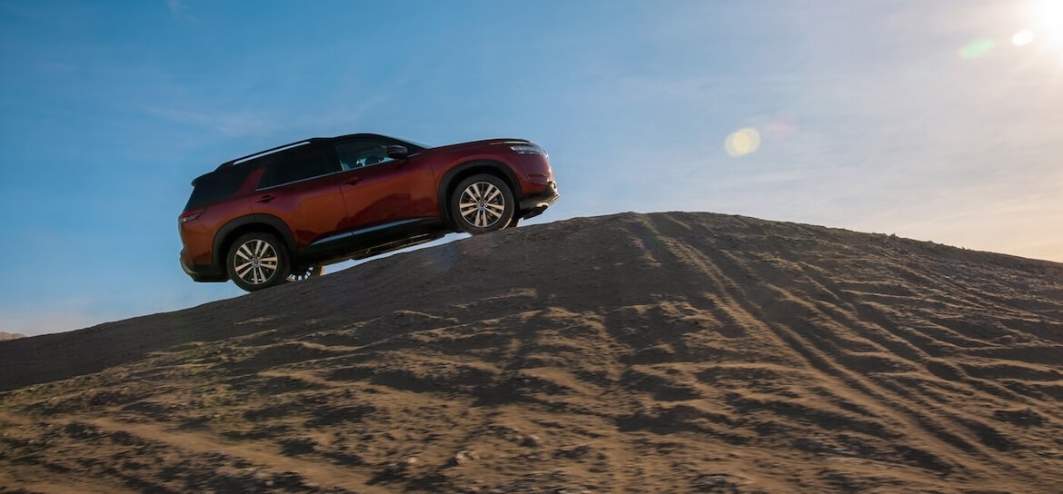  Nissan Pathfinder 2024 montant une montagne de sable.