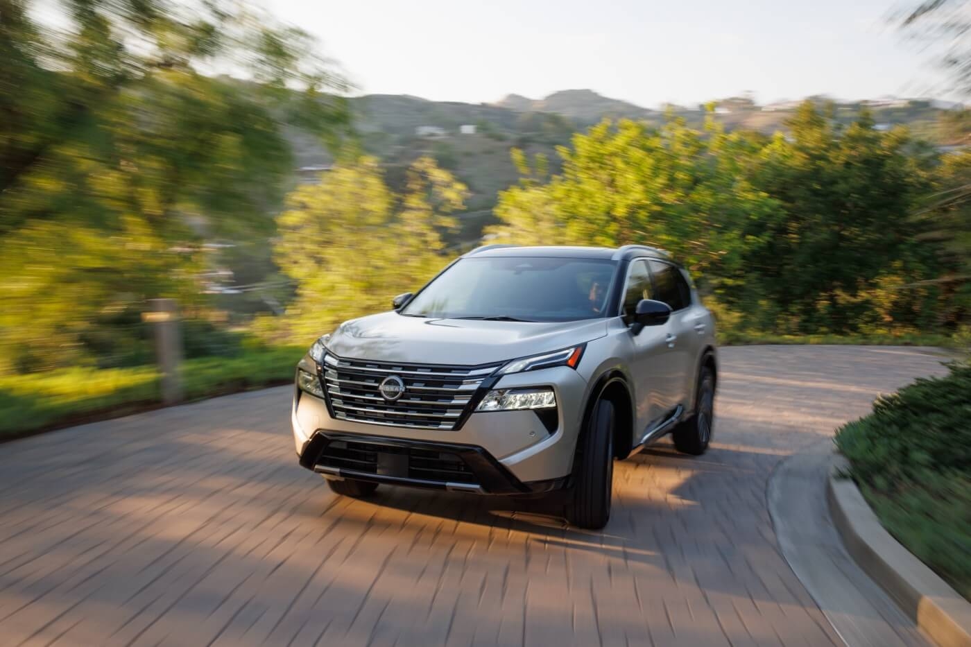Vue 3/4 avant du Nissan Rogue 2025 roulant sur un pavé.